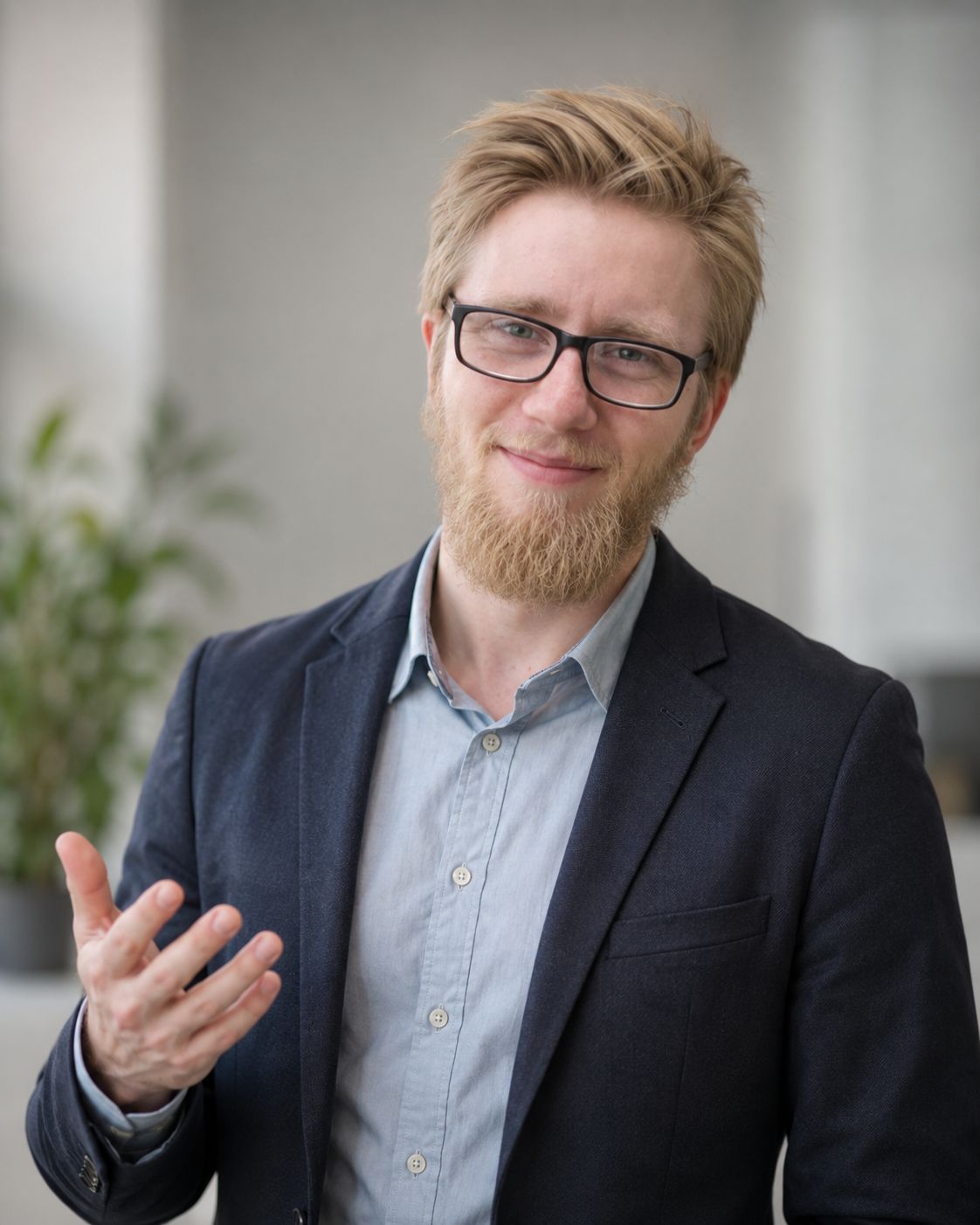 Dennis lächelt mit offener, einladender Handgeste